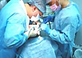 Врач-Имплантолог с ассистентом во время имплантации: пациенту М ввинчивают имплант